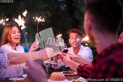 Image of happy friends having french dinner party outdoor