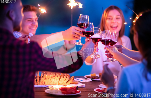 Image of happy friends having french dinner party outdoor