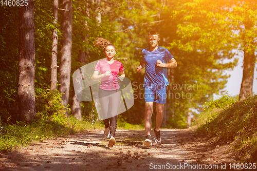 Image of young couple jogging on sunny day at nature