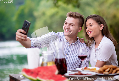 Image of young couple taking selfie on french dinner party outdoor