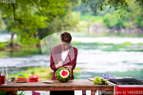 Image of Man cutting watermelon