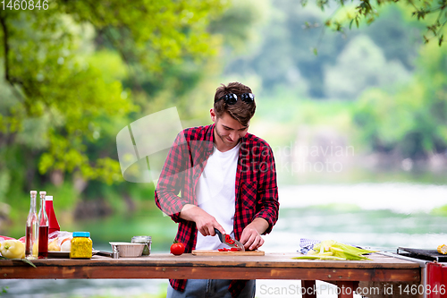 Image of Man cutting vegetables for salad or barbecue grill