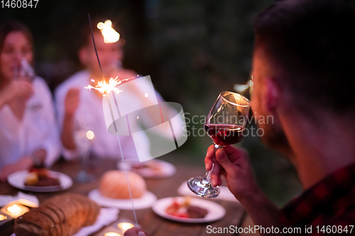 Image of happy friends having french dinner party outdoor