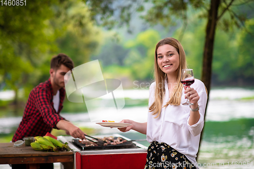 Image of happy couple having picnic french dinner party outdoor