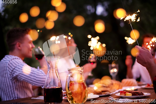 Image of happy friends having french dinner party outdoor