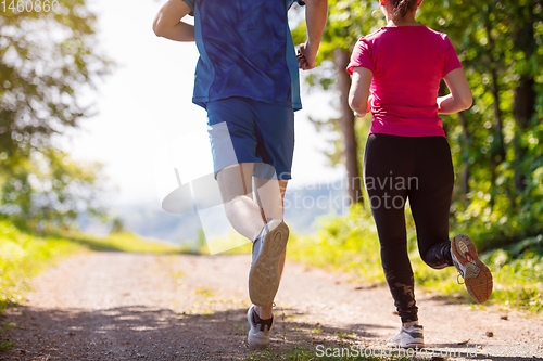 Image of young couple jogging on sunny day at nature