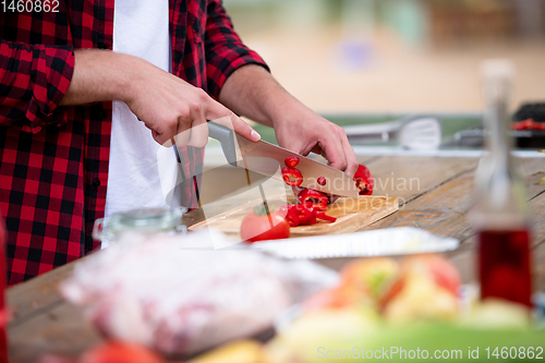 Image of Man cutting vegetables for salad or barbecue grill