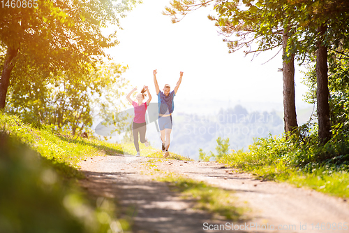 Image of young couple jogging on sunny day at nature