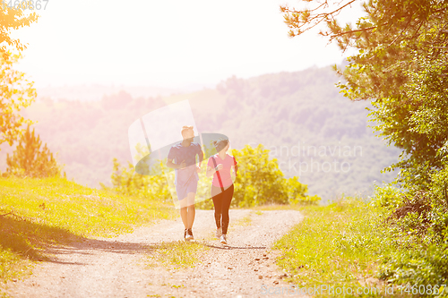 Image of young couple jogging on sunny day at nature