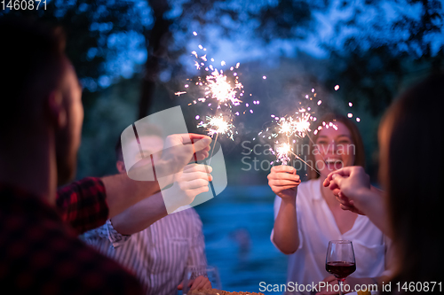 Image of happy friends having french dinner party outdoor