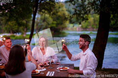 Image of happy friends having french dinner party outdoor