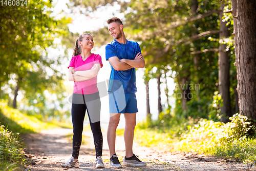 Image of portrait of young couple jogging on sunny day at nature