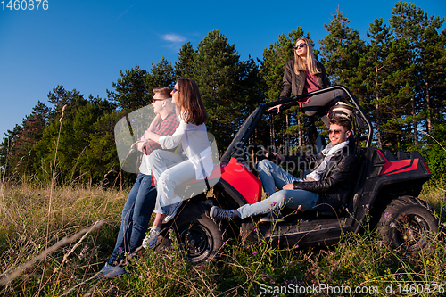 Image of group of young people driving a off road buggy car