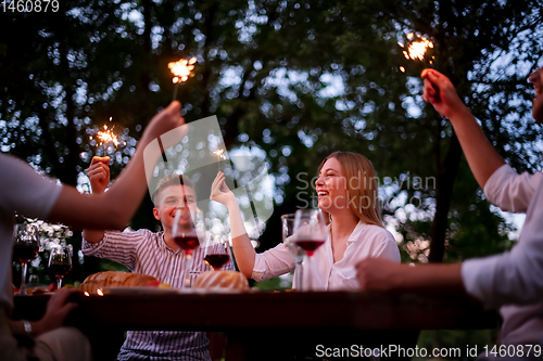 Image of happy friends having french dinner party outdoor