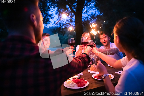 Image of happy friends having french dinner party outdoor