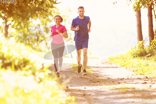 Image of young couple jogging on sunny day at nature