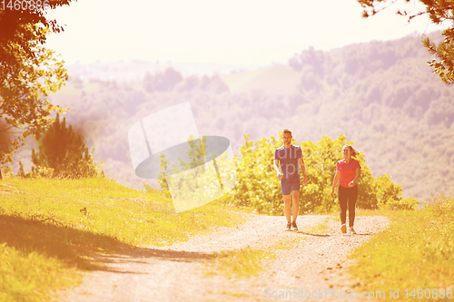 Image of young couple jogging on sunny day at nature