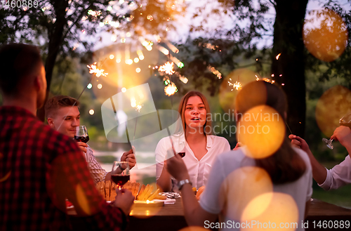 Image of happy friends having french dinner party outdoor