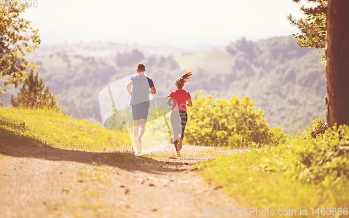 Image of young couple jogging on sunny day at nature