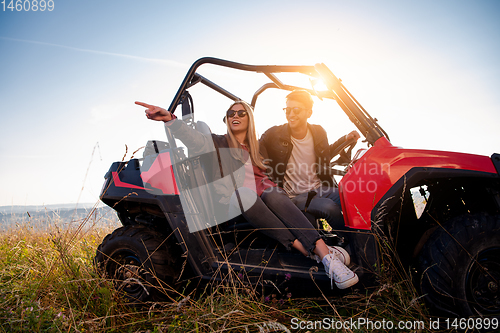 Image of young couple driving a off road buggy car