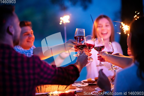 Image of happy friends having french dinner party outdoor