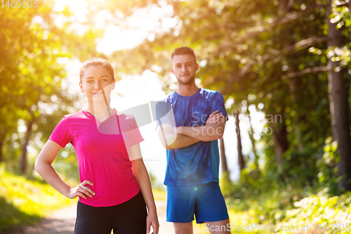 Image of portrait of young couple jogging on sunny day at nature
