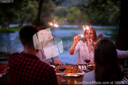 Image of happy friends having french dinner party outdoor