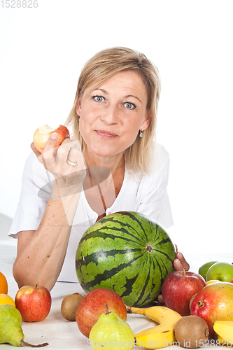 Image of Blond cute woman eating an apple