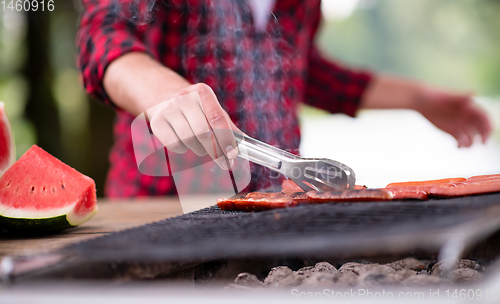 Image of Man cooking tasty food on barbecue grill