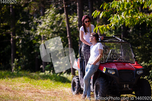 Image of young couple driving a off road buggy car