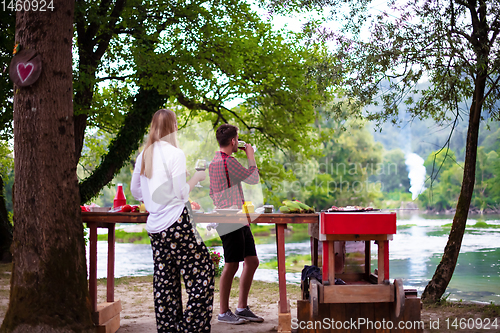 Image of happy couple having picnic french dinner party outdoor