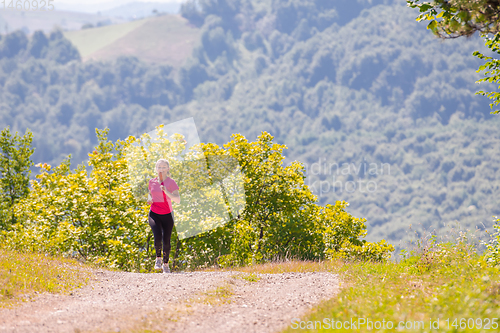 Image of young woman jogging on sunny day at nature