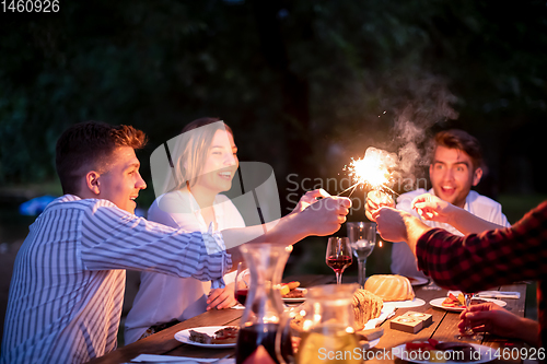 Image of happy friends having french dinner party outdoor