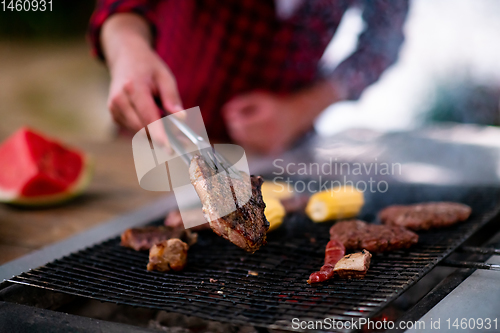 Image of Man cooking tasty food on barbecue grill