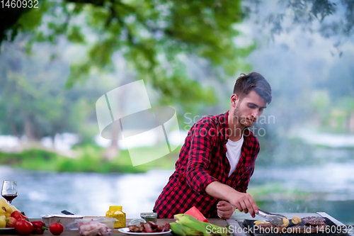 Image of Man cooking tasty food on barbecue grill