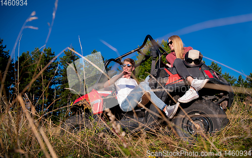 Image of young couple driving a off road buggy car