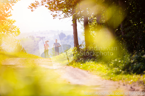 Image of young couple jogging on sunny day at nature