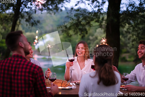 Image of happy friends having french dinner party outdoor