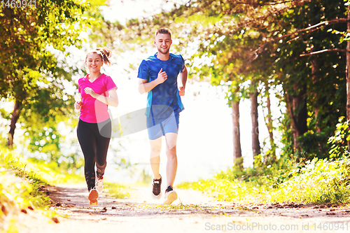 Image of young couple jogging on sunny day at nature