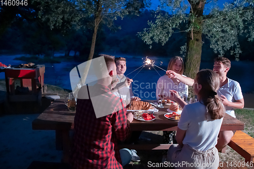 Image of happy friends having french dinner party outdoor