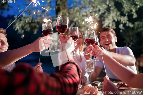 Image of happy friends having french dinner party outdoor