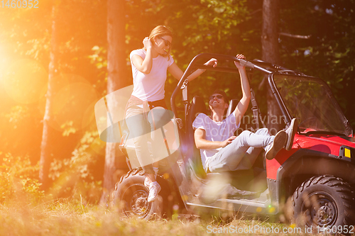 Image of young couple driving a off road buggy car