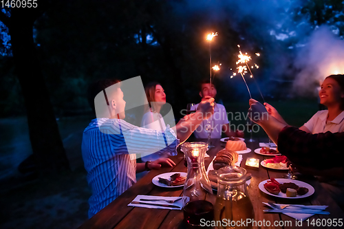 Image of happy friends having french dinner party outdoor