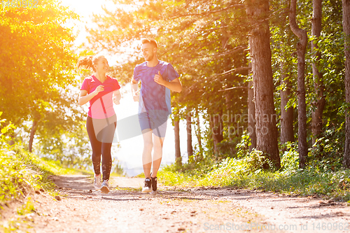 Image of young couple jogging on sunny day at nature