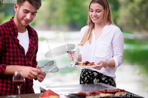 Image of happy couple having picnic french dinner party outdoor