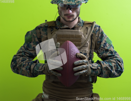 Image of solder holding american football ball