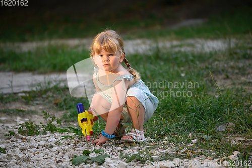 Image of Little blonde girl with a water pistol