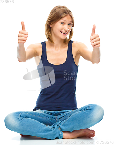 Image of Young happy woman is showing thumb up sign