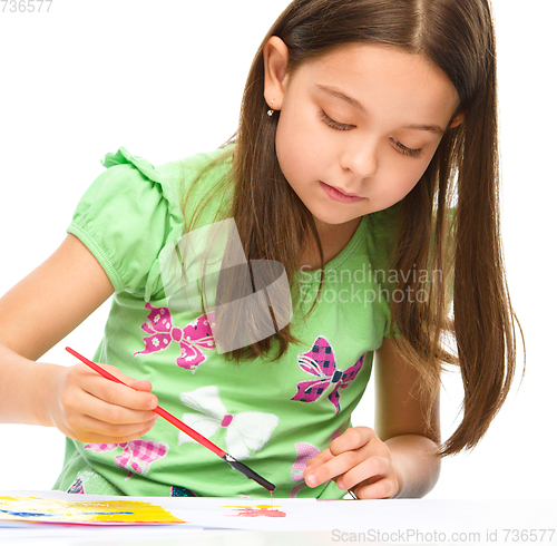 Image of Little girl is painting with gouache