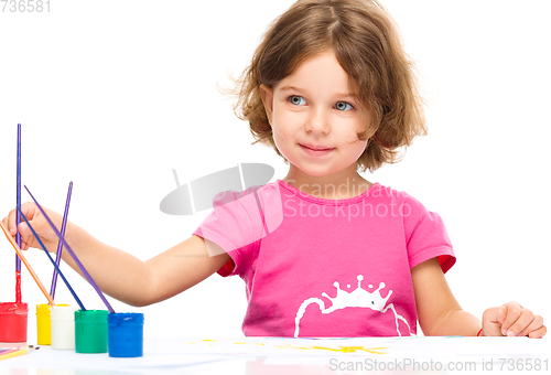 Image of Little girl is painting with gouache